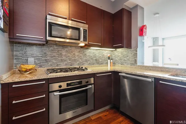 a kitchen with granite countertop wooden cabinets and stainless steel appliances