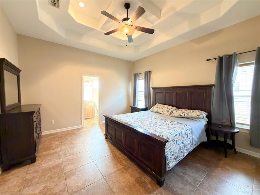 208 North 15th Street Hidalgo, TX 78557 - Photo 24 of 26 a spacious bedroom with a bed and a chandelier