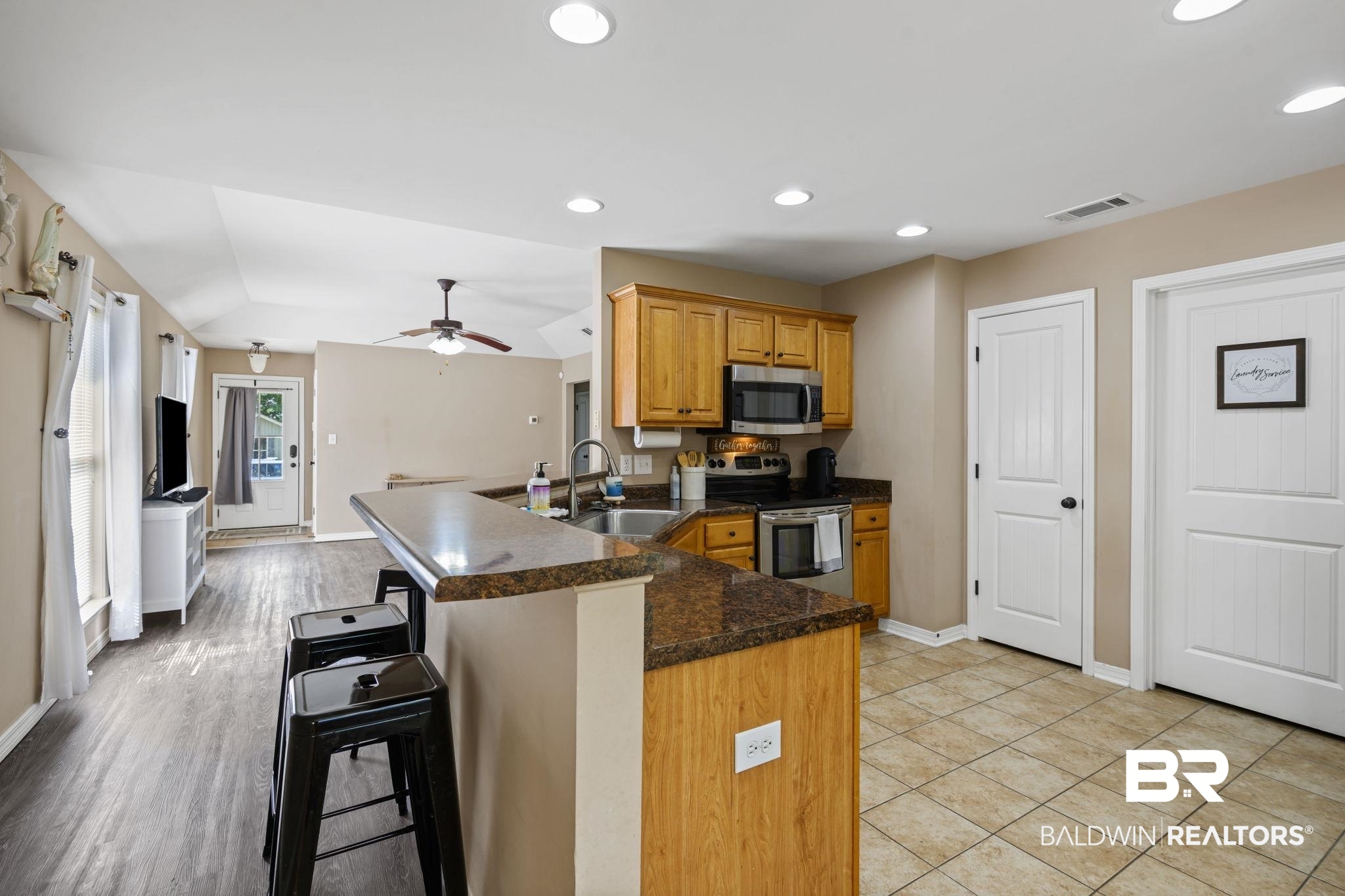 8956 Spring Grove North Mobile, AL 36695 - Photo 5 of 19 Kitchen featuring appliances with stainless steel finishes, a sink, a peninsula, baseboards, and a kitchen breakfast bar