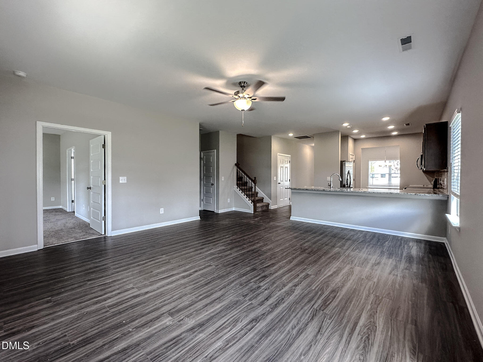349 Spirit Spgs Road Smithfield, NC 27577 - Photo 9 of 23 a view of an empty room with wooden floor and a kitchen