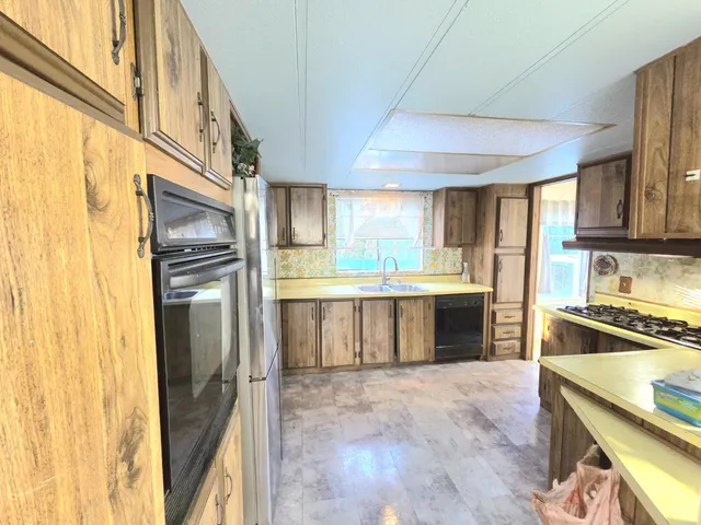 a kitchen with a sink a refrigerator and window