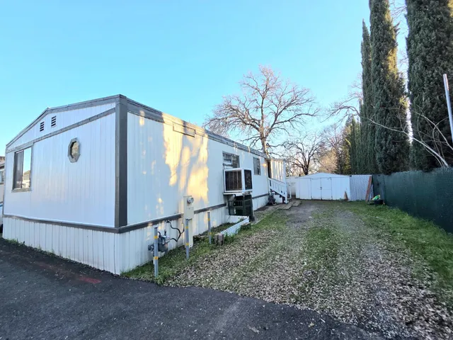 a backyard of a house with barbeque oven table and chairs