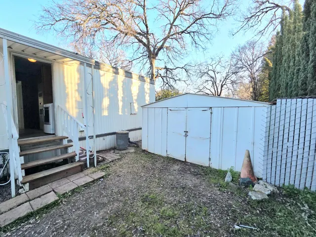 a view of a house with a yard and wooden fence