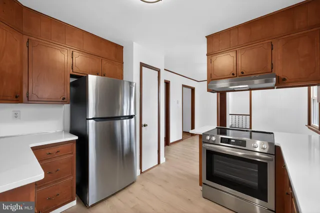 a kitchen with stainless steel appliances granite countertop wooden cabinets a sink and dishwasher with wooden floor