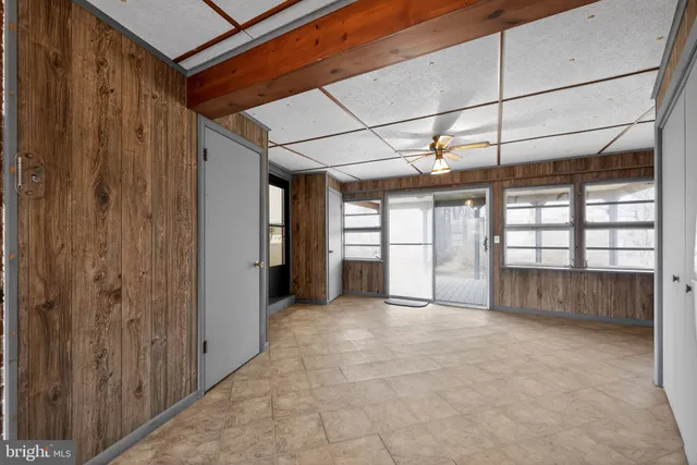 a view of a room with a ceiling fan and refrigerator