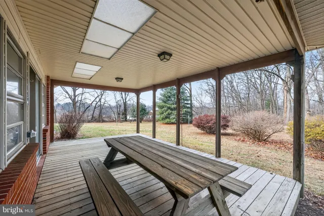 a view of a patio with table and chairs with plants and trees