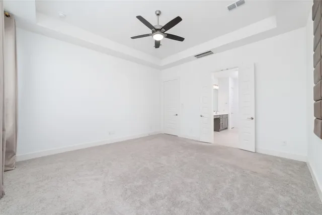 an empty room with closet and a ceiling fan