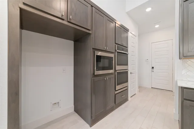 a kitchen with white cabinets and stainless steel appliances
