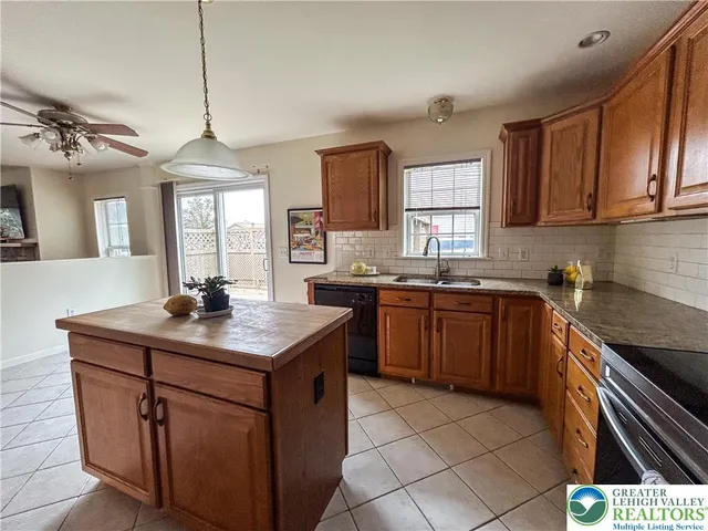 a kitchen with a sink a stove cabinets and a window