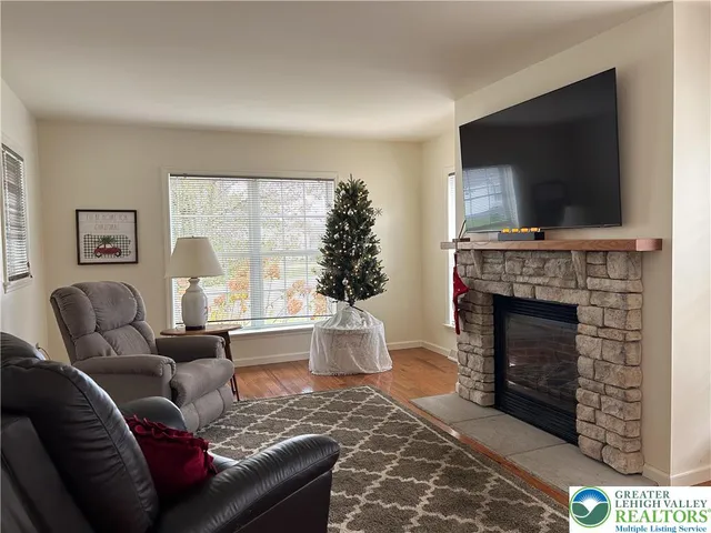 a living room with furniture a flat screen tv and a fireplace
