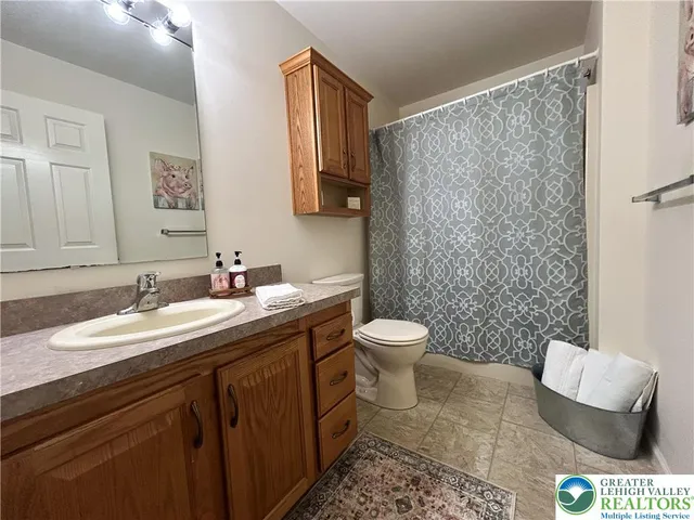 a bathroom with a granite countertop sink a mirror and a toilet
