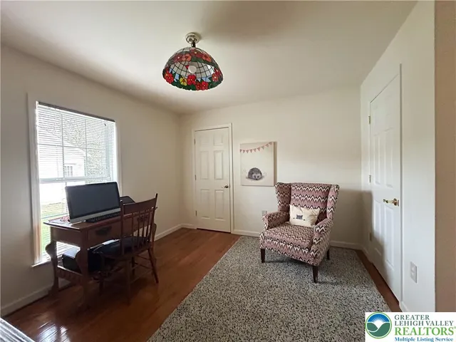 a view of a workspace with furniture and a window