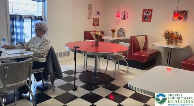 a living room with furniture a table and a large mirror with wooden floor