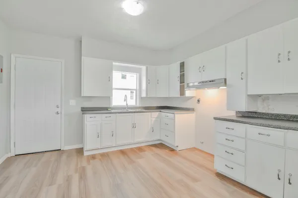 a kitchen with granite countertop white cabinets and white appliances