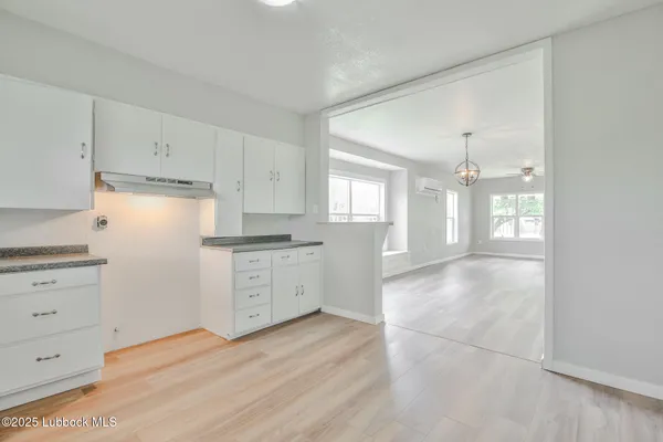 a kitchen with granite countertop white cabinets and white appliances