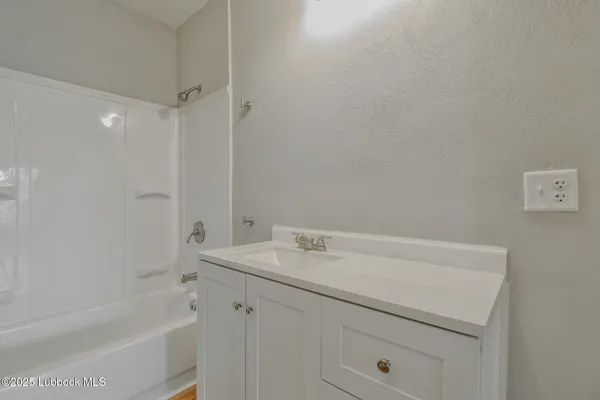 a bathroom with a sink a vanity and a bathtub