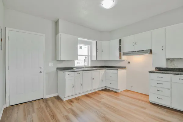 a kitchen with granite countertop white cabinets and white appliances