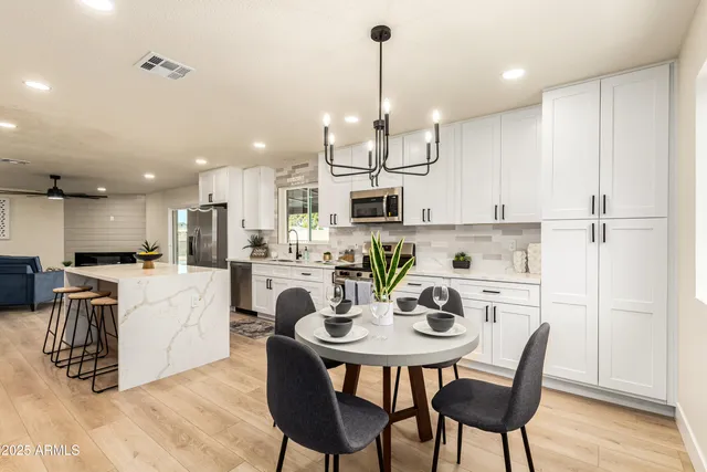 a kitchen with kitchen island a dining table and chairs
