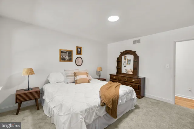 a bedroom with a bed and a potted plant