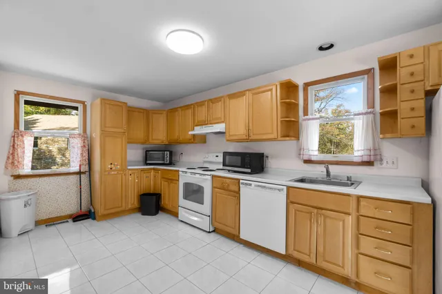 a large kitchen with a stove a sink a microwave and a dining table