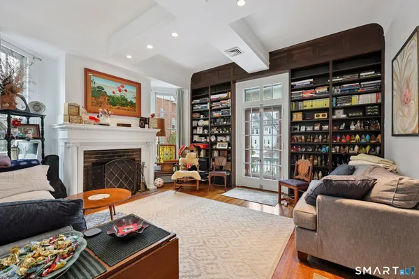 a living room with furniture a bookshelf and a fireplace