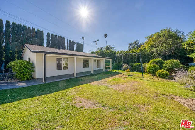 a view of a house with backyard and garden
