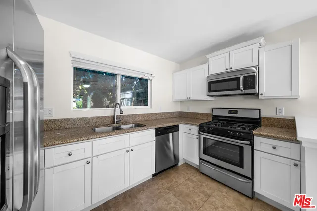 a kitchen with appliances a sink and cabinets