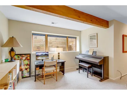 a living room with furniture a desk and a large window