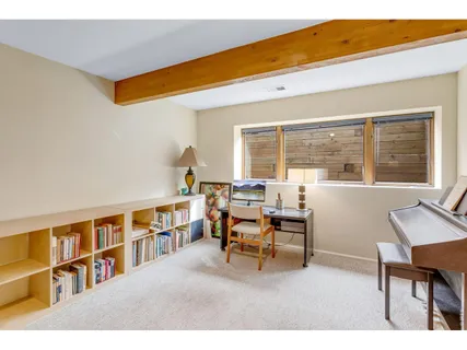 a living room with furniture a bookshelf and a window