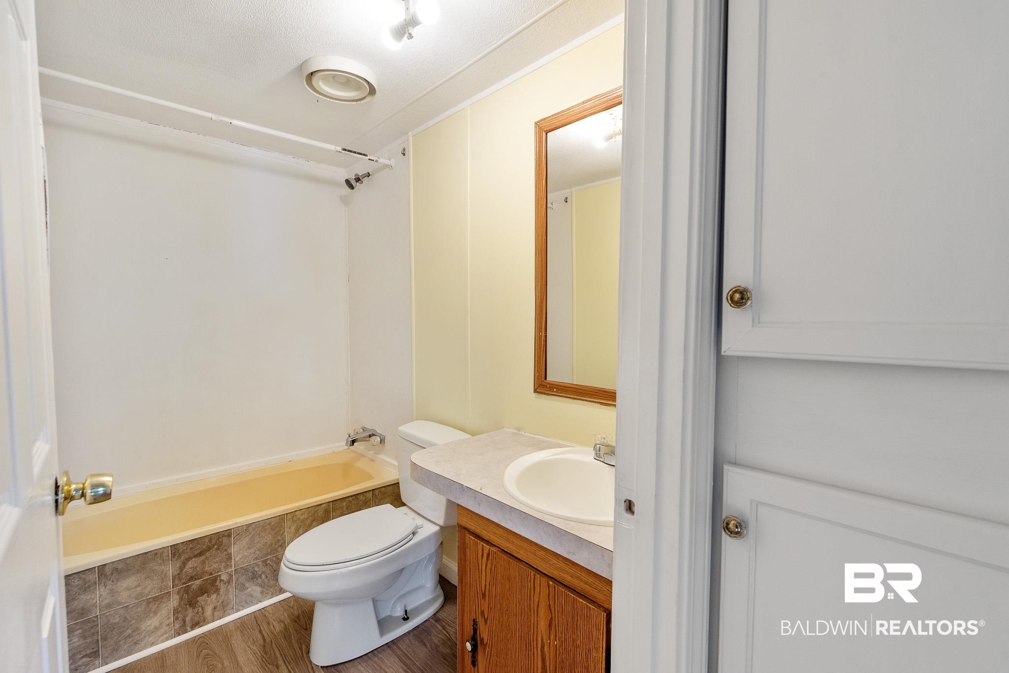 7695 Bermuda Drive Semmes, AL 36575 - Photo 25 of 27 Bathroom with vanity, shower / bathing tub combination, toilet, and wood finished floors