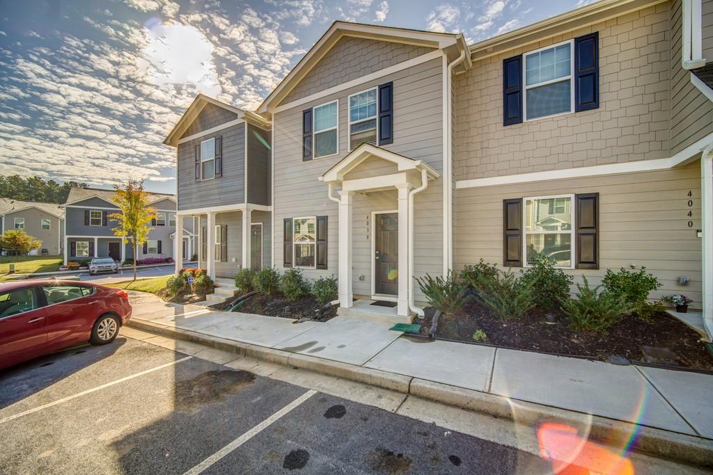 a front view of a house with garden and plants