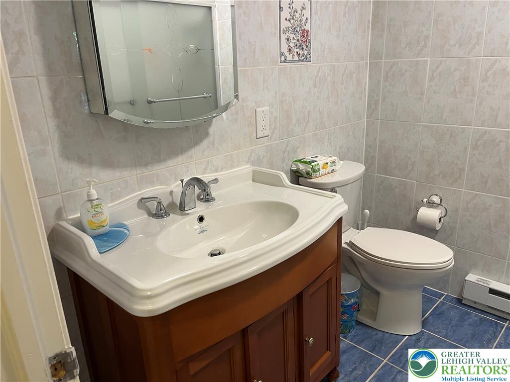 6221 Dove Drive Bethlehem, PA 18017 - Photo 22 of 38 Floor-to-ceiling wall tiles and classic woodwork define this practical bathroom space.