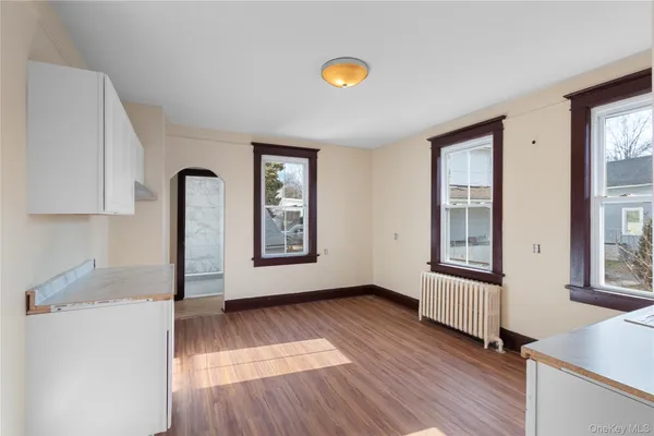 a view of an empty room with glass door and wooden floor