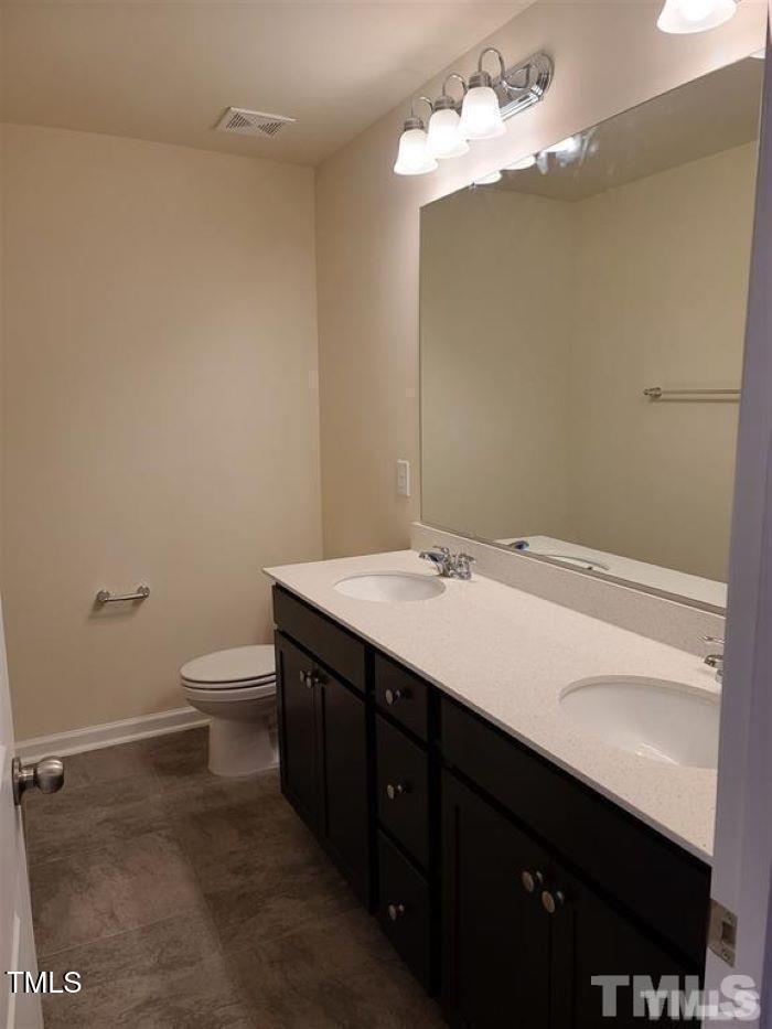 401 Purdue Drive Durham, NC 27713 - Photo 2 of 14 a bathroom with a sink a toilet and a mirror