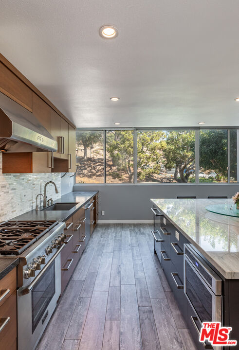 17352 Sunset Boulevard, Unit 202 Pacific Palisades, CA 90272 - Photo 13 of 30 a kitchen with stainless steel appliances granite countertop a stove and a wooden floors