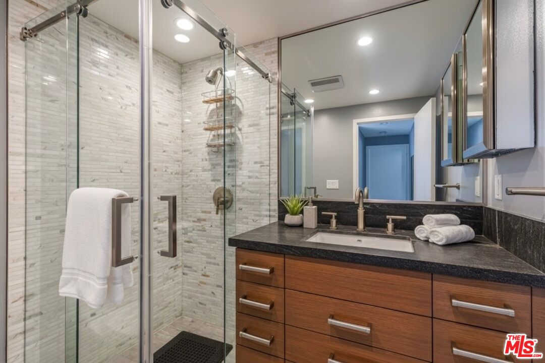 17352 Sunset Boulevard, Unit 202 Pacific Palisades, CA 90272 - Photo 14 of 30 a bathroom with a double vanity sink a mirror and shower