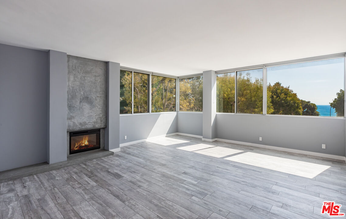 17352 Sunset Boulevard, Unit 202 Pacific Palisades, CA 90272 - Photo 5 of 30 a view of an empty room with wooden floor and a fireplace