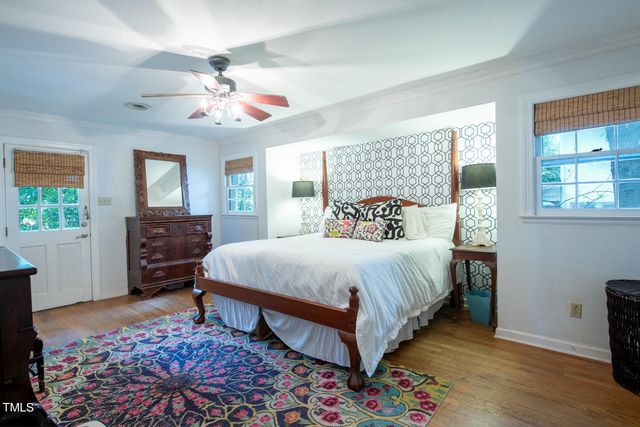 a bedroom with a large bed a chandelier and a window