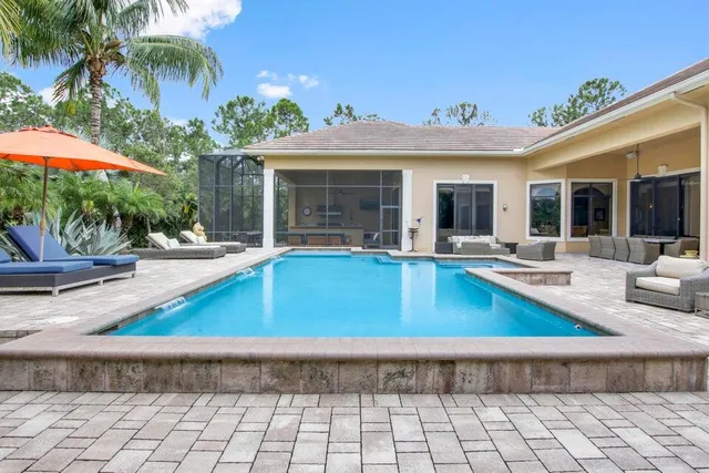 a view of a house with swimming pool and sitting area