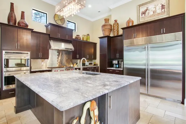 a kitchen with stainless steel appliances granite countertop a sink refrigerator and microwave