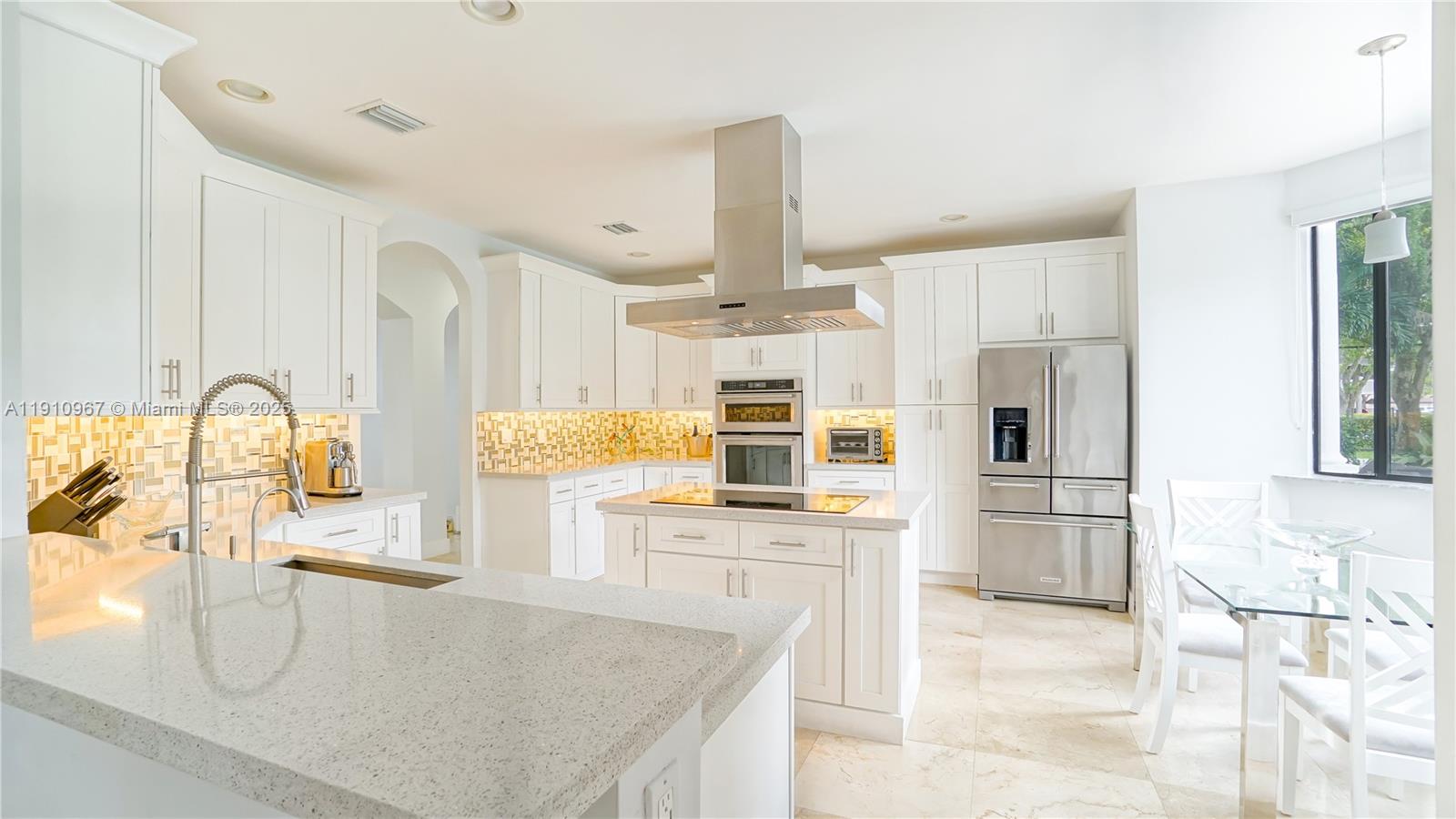 6950 Southwest 97th Avenue Miami, FL 33173 - Photo 16 of 22 a kitchen with stainless steel appliances kitchen island granite countertop a refrigerator and a stove top oven
