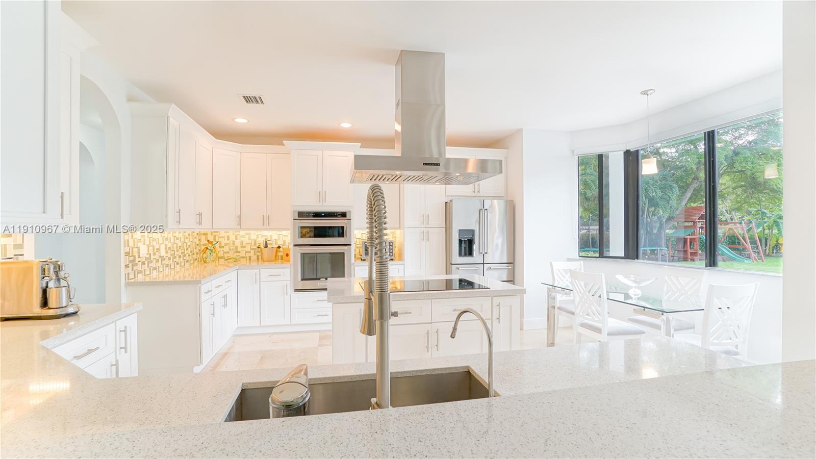 6950 Southwest 97th Avenue Miami, FL 33173 - Photo 17 of 22 a kitchen with stainless steel appliances kitchen island granite countertop a refrigerator and a sink