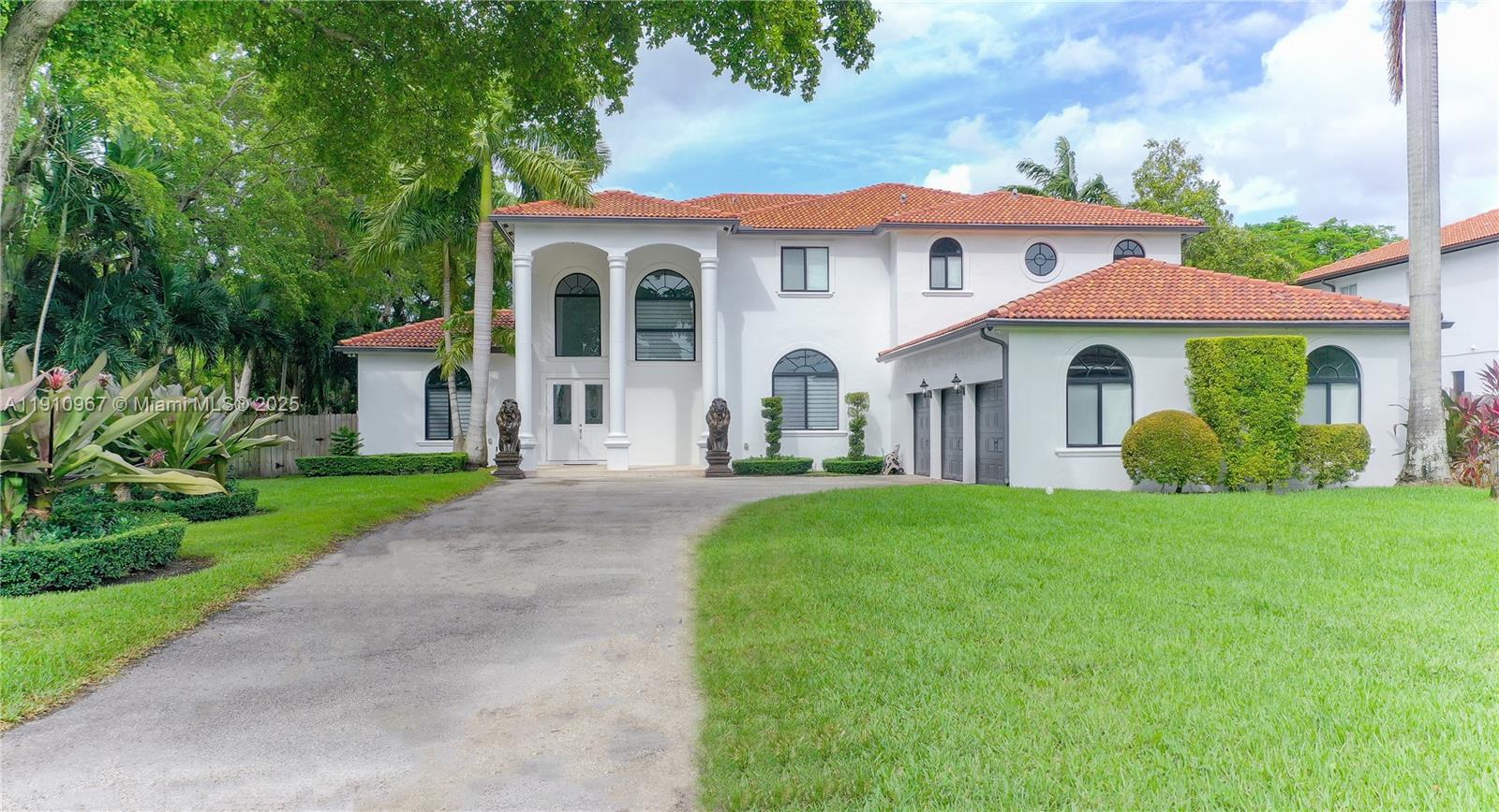 6950 Southwest 97th Avenue Miami, FL 33173 - Photo 3 of 22 a view of a white house with a big yard plants and large trees