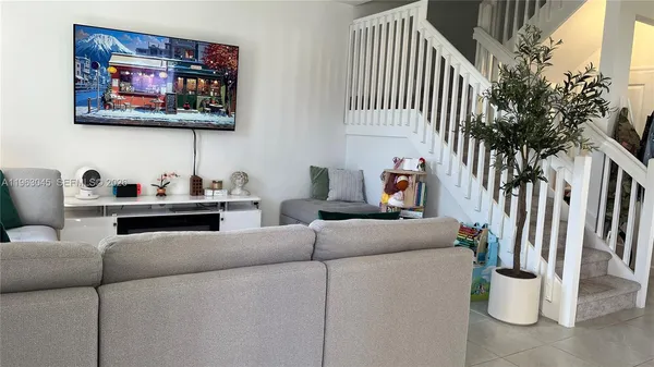 a living room with furniture and a potted plant
