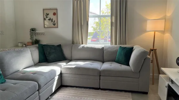 a view of a workspace with furniture and a window