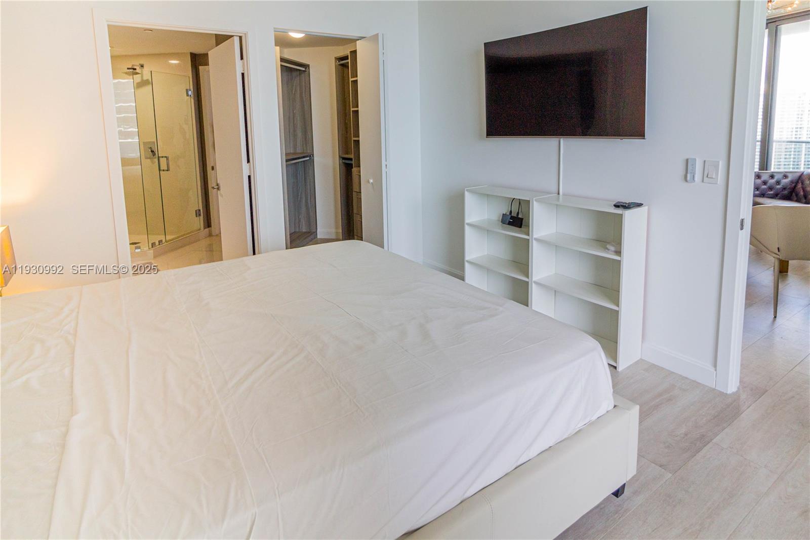 45 Southwest 9th Street, Unit 3601 Miami, FL 33130 - Photo 13 of 19 a bedroom with a bed and a flat screen tv