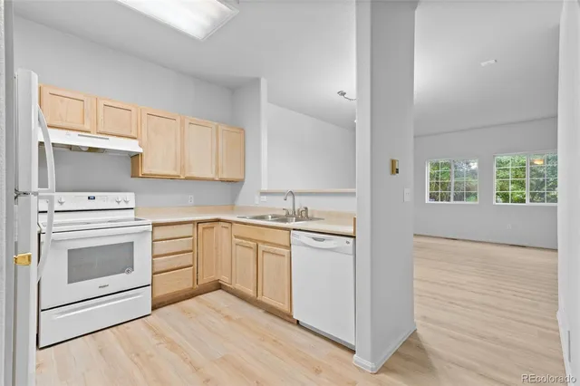 a kitchen with granite countertop white cabinets and white appliances
