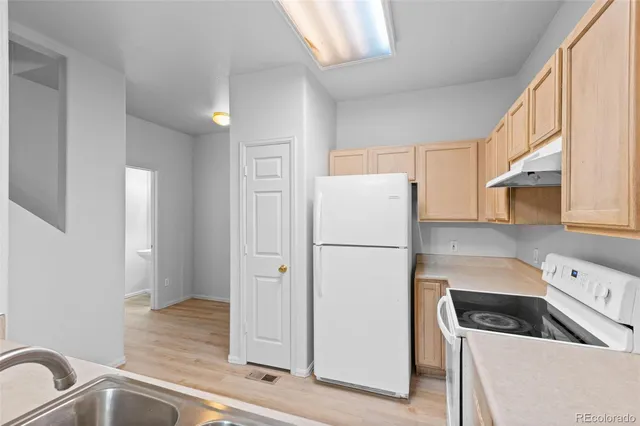 a kitchen with a refrigerator sink and cabinets