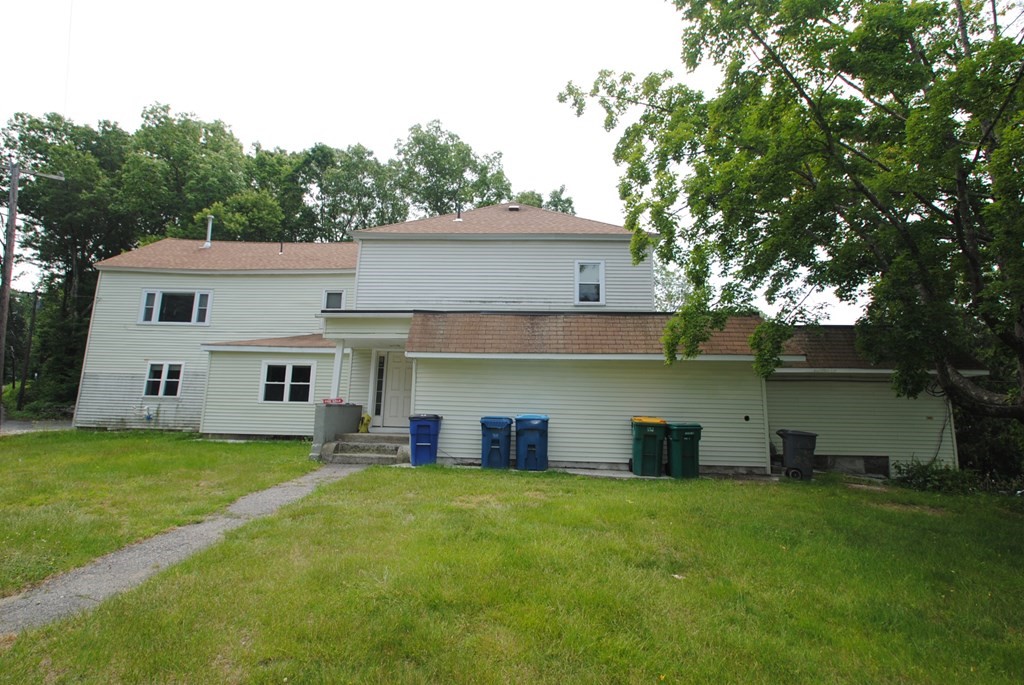 16 Hartness Road, Unit D Sutton, MA 01590 - Photo 13 of 16 a front view of house with yard and trees in the background