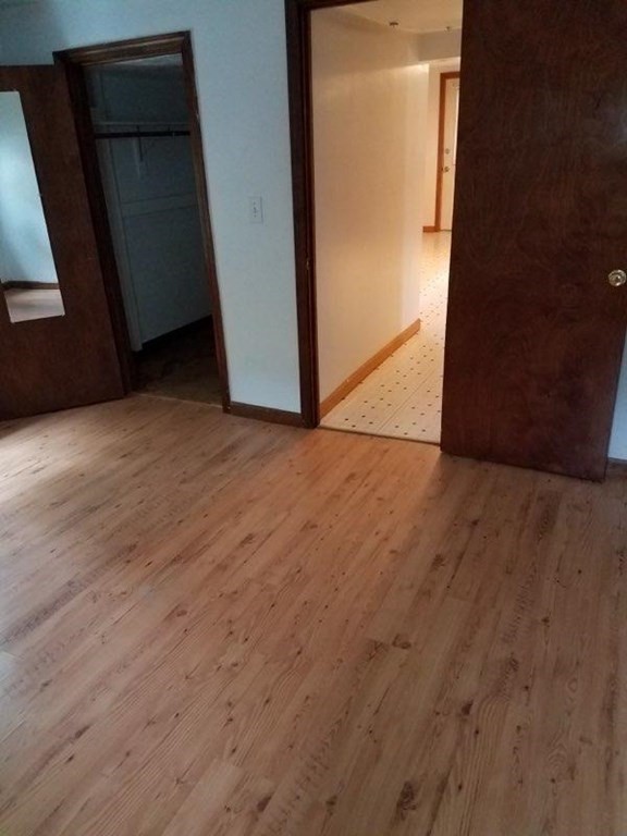 16 Hartness Road, Unit D Sutton, MA 01590 - Photo 6 of 16 a view of an empty room with wooden floor and a window